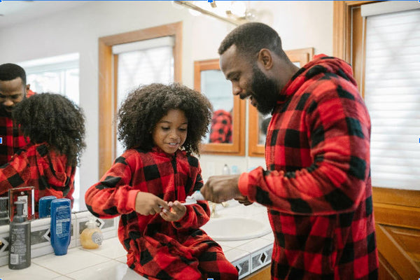 Father and daughter getting ready to brush their teeth.