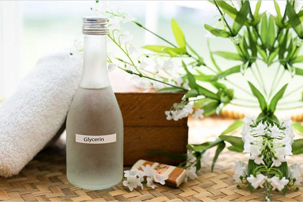 A clear bottle on glycerin with plants and home goods in the background.